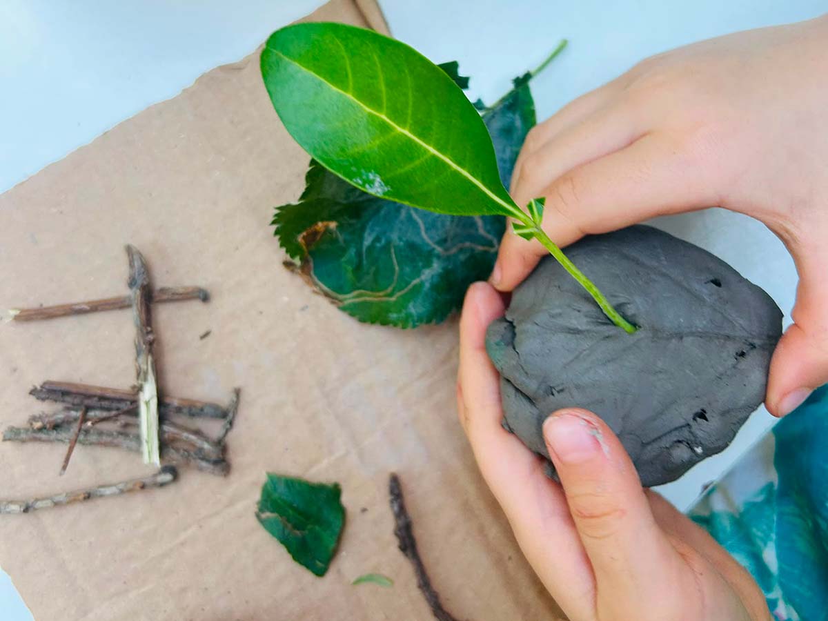 Children playing with clay and leaves - exploring nature