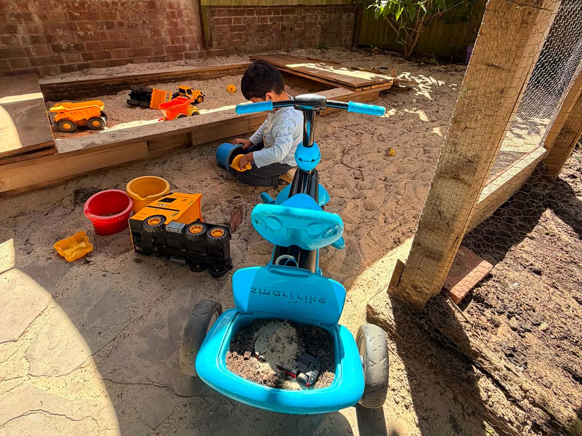 child playing in sandpit woodlands nursery play learn grow